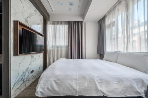 a bedroom with a white bed and a window at Dream Mansion Hotel in Taichung
