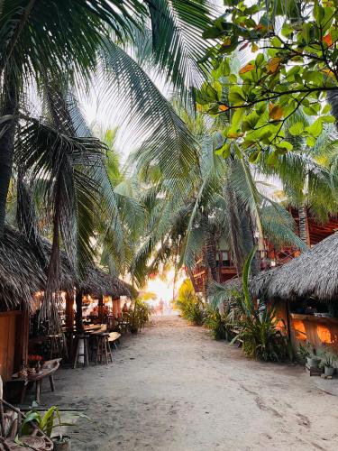 a resort with palm trees and tables and chairs at Blue House in Puerto Escondido