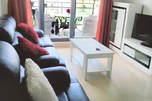 a living room with a couch and a table at Comfortable Apartment in Almería with Shared Pool - 72 m² in Retamar