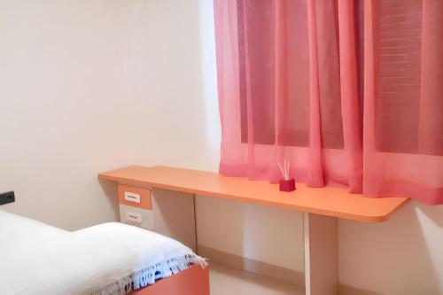 sypialnia z biurkiem i czerwoną zasłoną w obiekcie Comfortable Apartment in Almería with Shared Pool - 72 m² w mieście Retamar