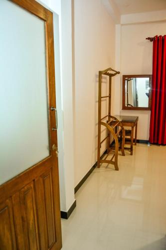 a room with a door and a chair and a table at Ocean Bliss Villa Mirissa in Kamburugamuwa