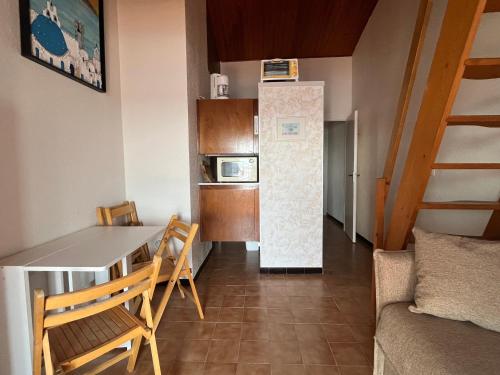 une petite cuisine avec une table et un réfrigérateur dans l'établissement Studio Mezzanine 4P avec Vue, Parking Privé - Le Barcarès - FR-1-799-16, au Barcarès