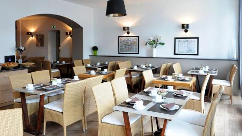 a dining room with tables and chairs at Hotel Cote Basque in Bayonne