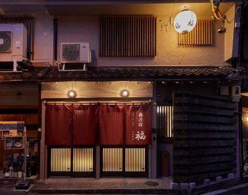 a store front with a gate with red curtains at 奥乃宿 福 in Osaka