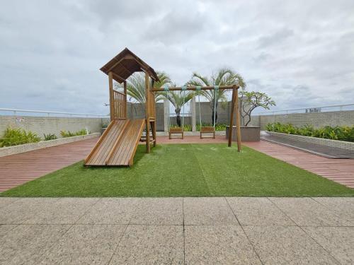 a playground with a slide and a swing set at Apartamento em Maceió a beira mar in Maceió