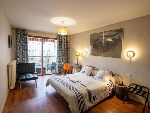 une chambre avec un lit, une chaise et une fenêtre dans l'établissement Élégant 3 pièces avec balcon, centre de Périgueux, proche cathédrale et marché - FR-1-616-326, à Périgueux