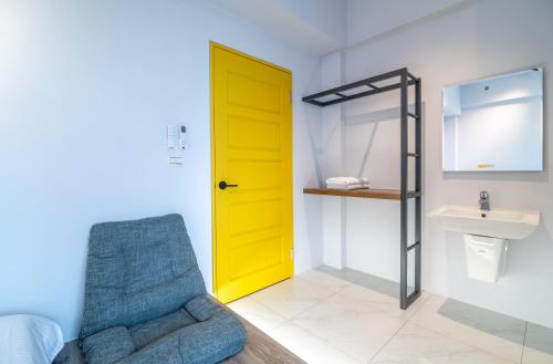 a bathroom with a yellow door and a sink at 歸巢民宿 Homecoming in Jiaoxi