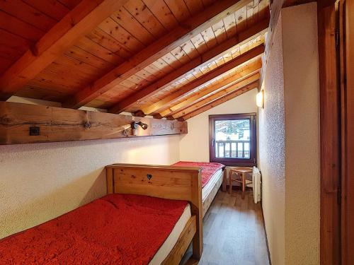Cette chambre dispose de deux lits et d'un plafond en bois. dans l'établissement Appartement 8 pers à La Clusaz, Wifi, animaux admis, parking - FR-1-818-23, à La Clusaz