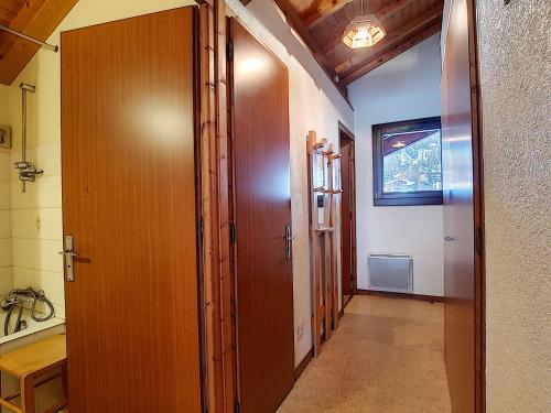 un couloir avec une porte en bois et une salle de bain dans l'établissement Appartement 8 pers à La Clusaz, Wifi, animaux admis, parking - FR-1-818-23, à La Clusaz