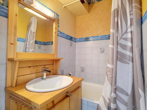 une salle de bain avec un lavabo, un miroir et une baignoire dans l'établissement Studio cosy à La Clusaz avec balcon et garage, animaux admis - FR-1-818-9, à La Clusaz
