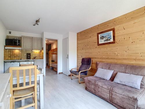 un salon avec un canapé et une cuisine dans l'établissement Appartement cosy avec balcon Sud et wifi, animaux admis - FR-1-818-41, à La Clusaz