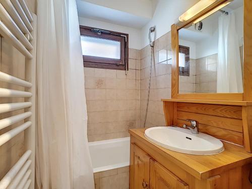 une salle de bain avec un lavabo, un miroir et une baignoire dans l'établissement Appartement cosy avec balcon Sud et wifi, animaux admis - FR-1-818-41, à La Clusaz