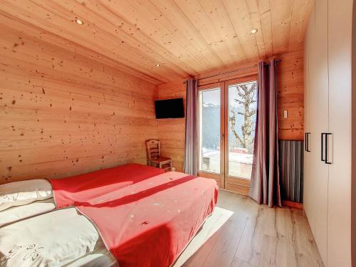 une chambre avec un lit dans une cabane en bois dans l'établissement Charmant appart 4 pers à La Clusaz avec parking et wifi - FR-1-818-46, à La Clusaz