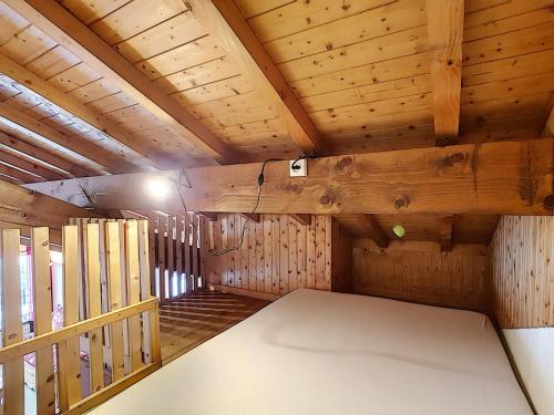 Cette chambre est dotée de murs et de plafonds en bois ainsi que d'un grand lit. dans l'établissement La Clusaz: Apt pour 8 pers, 2 chambres, parking, wifi, animaux - FR-1-818-26, à La Clusaz