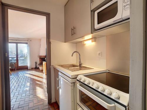 une cuisine avec un évier et un micro-ondes dans l'établissement Studio confortable à La Clusaz - Animaux admis, Parking - FR-1-818-45, à La Clusaz