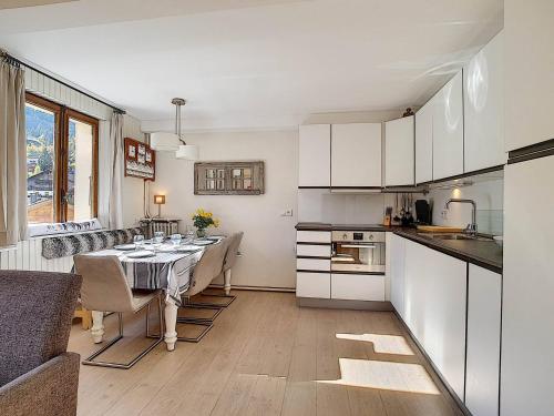 Il comprend une cuisine et une salle à manger avec une table et des chaises. dans l'établissement Appartement 7 pers, 3 chambres, Wifi, Animaux acceptés, La Clusaz - FR-1-818-40, à La Clusaz