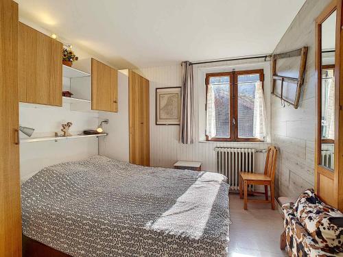 拉克吕萨Appartement 7 pers, 3 chambres, Wifi, Animaux acceptés, La Clusaz - FR-1-818-40的一间卧室，里面有一张床、一把椅子和一扇窗户