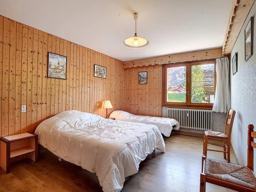 une chambre avec deux lits et une fenêtre dans l'établissement Appartement 5 pers à La Clusaz - Animaux admis - FR-1-818-60, à La Clusaz