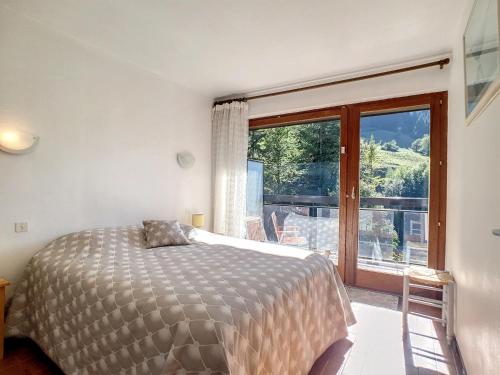 une chambre avec un lit et une grande fenêtre dans l'établissement La Clusaz : Apt cosy 5 pers, parking, animaux OK - FR-1-818-57, à La Clusaz
