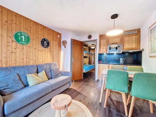 un salon avec un canapé bleu et une cuisine dans l'établissement La Clusaz : Appartement 6 pers avec Wifi et parking, animaux admis - FR-1-818-86, à La Clusaz