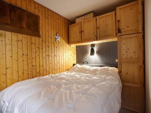 - une chambre avec un grand lit et des placards en bois dans l'établissement La Clusaz : Appartement 6 pers avec Wifi et parking, animaux admis - FR-1-818-86, à La Clusaz