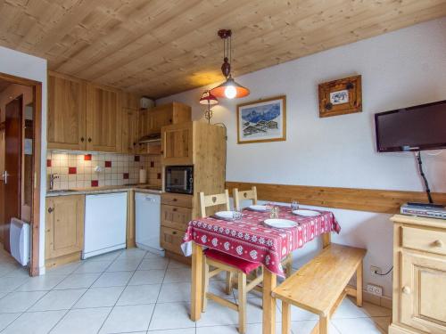 une cuisine avec une table et des chaises dans une pièce dans l'établissement Studio cosy avec balcon et wifi, animaux admis - La Clusaz - FR-1-818-84, à La Clusaz