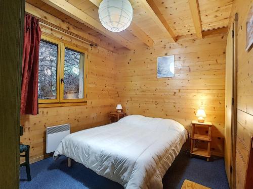 une chambre avec un lit dans une cabane en bois dans l'établissement Chalet La Clusaz 6 pers, cheminée, WIFI, animaux admis, parking - FR-1-818-93, à La Clusaz