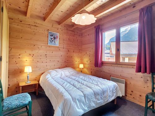 une chambre avec un lit dans une cabane en rondins dans l'établissement Demi-chalet à La Clusaz, 6 pers, cheminée, parking, wifi - FR-1-818-100, à La Clusaz