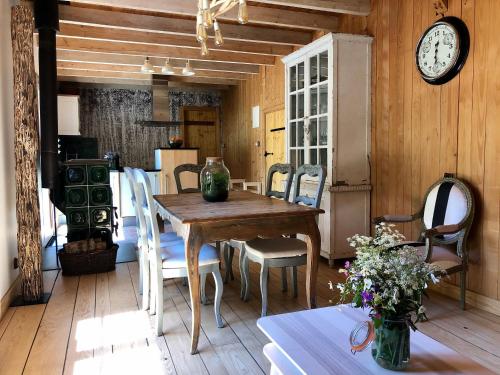 une salle à manger avec une table et une horloge au mur dans l'établissement Gîte Tranquille à la Ferme Vosgienne avec Parking - FR-1-589-779, à Sapois
