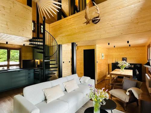 - un salon avec un canapé blanc et un escalier dans l'établissement Chalet moderne avec cheminée et animaux bienvenus proche de Gérardmer - FR-1-589-778, à Sapois