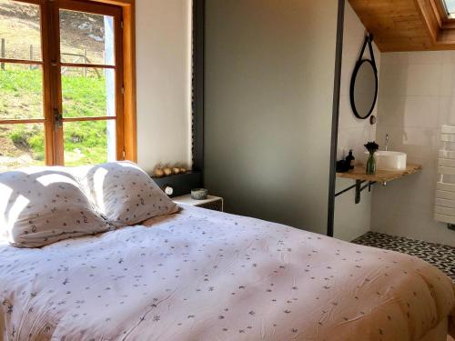 une chambre avec un lit blanc avec une fenêtre dans l'établissement Gîte Tranquille à la Ferme Vosgienne avec Parking - FR-1-589-779, à Sapois