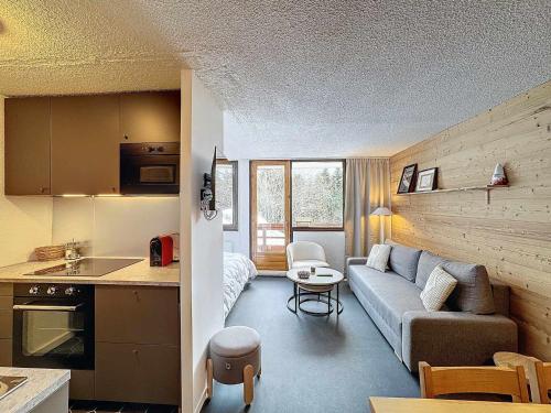 un petit salon avec un canapé et une cuisine dans l'établissement Appartement cosy 4 pers à Reberty 1850, balcon plein soleil, accès pistes, cuisine équipée - FR-1-178-399, aux Menuires