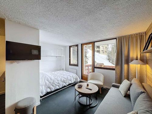 une pièce avec un canapé, un lit et une table dans l'établissement Appartement cosy 4 pers à Reberty 1850, balcon plein soleil, accès pistes, cuisine équipée - FR-1-178-399, aux Menuires