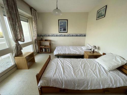 une chambre avec deux lits et une fenêtre dans l'établissement Appartement proche plage, animaux admis, parking privatif - FR-1-324A-70, à Saint-Hilaire-de-Riez