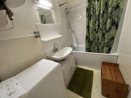 La petite salle de bains est pourvue d'un lavabo et d'un rideau de douche. dans l'établissement Appartement proche plage, animaux admis, parking privatif - FR-1-324A-70, à Saint-Hilaire-de-Riez
