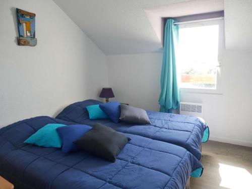 - un lit bleu dans une chambre avec fenêtre dans l'établissement Maison cosy 4 pièces à Erdeven, proche plage, jardin clos, animaux admis, parking privé - FR-1-479-208, à Erdeven