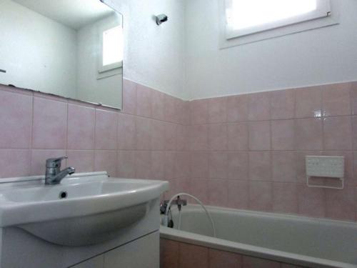 une salle de bain avec un lavabo, une baignoire et un miroir dans l'établissement Maison cosy 4 pièces à Erdeven, proche plage, jardin clos, animaux admis, parking privé - FR-1-479-208, à Erdeven