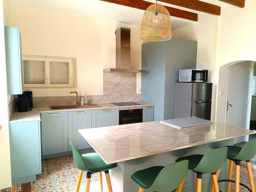 une cuisine avec comptoir et tabourets de bar verts dans l'établissement Maison moderne sur l'île avec jardin et Wi-Fi, proche plage - FR-1-368-450, à Pleumeur-Bodou