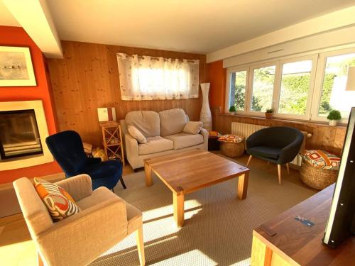 un salon avec un canapé, des chaises et une table dans l'établissement Maison moderne à deux pas de la plage avec jardin et parking à Trégastel - FR-1-368-451, à Trégastel