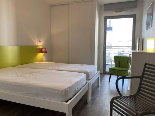 une chambre avec un lit, une chaise et une fenêtre dans l'établissement Royan - T2 Bord de Mer - Centre-ville avec Parking - FR-1-738-33, à Royan