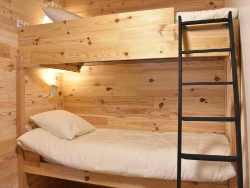 Ce lit superposé se trouve dans une cabane en rondins avec une échelle. dans l'établissement Appartement 4 pièces pour 6 pers, parking et balcon à Méribel - FR-1-180-652, à Les Allues