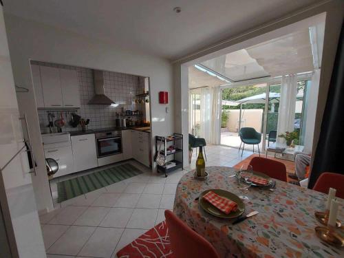 une cuisine et une salle à manger avec une table et une salle à manger dans l'établissement Appartement 3 pièces avec terrasse, clim et WIFI, proche plage et commerces - FR-1-423-312, au Grau-dʼAgde
