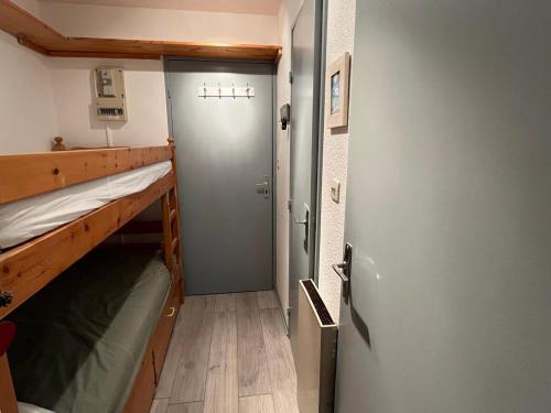 Cette petite chambre dispose d'une porte et de lits superposés. dans l'établissement Studio cosy à Samoëns - 4 pers, animaux admis, parking privé - FR-1-629-144, à Samoëns