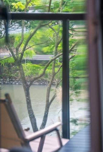 a chair sitting on a porch looking out a window at 歸巢民宿 Homecoming in Jiaoxi