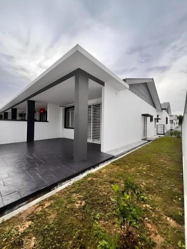 a white house with a large patio in a yard at The Nogori Homestay 86 by DUDUK SANTAI SIGNATURE in Seremban