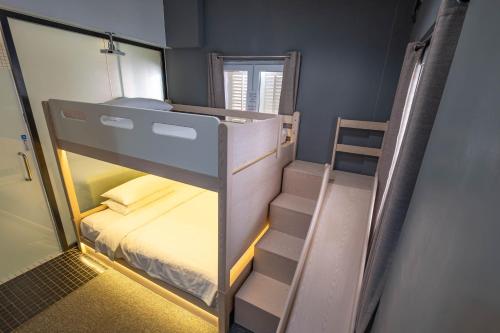 a small room with a bunk bed and a staircase at Rest Chinatown Hotel in Singapore