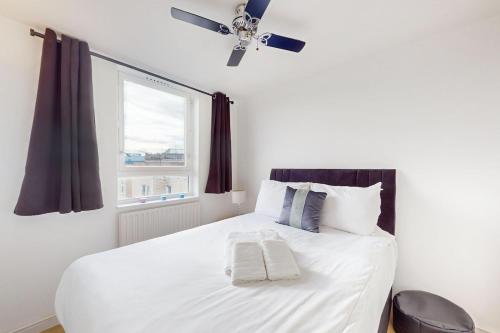 a bedroom with a white bed with a ceiling fan at Amazing location 1 BD flat on St Katharine's Docks in London