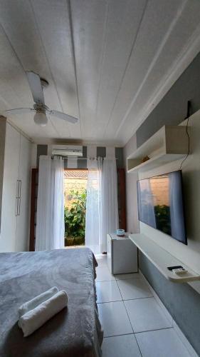 a bedroom with a bed and a large window at Suítes Canto do Pontal in Paraty