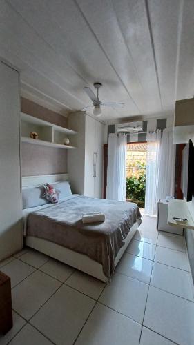 a bedroom with a large bed and a large window at Suítes Canto do Pontal in Paraty