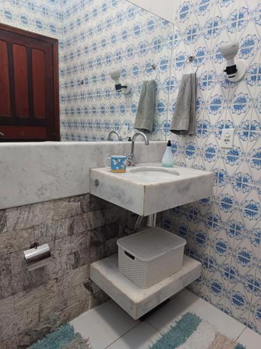 a bathroom with a sink and blue and white tiles at Suítes Canto do Pontal in Paraty